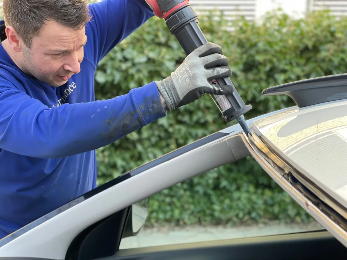 Auto glass technician applying urethane for a windshield in Cocoa
